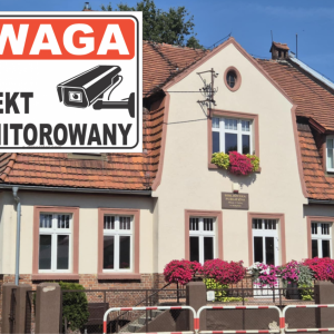 Zdjęcie przedstawia budynek Biblioteki Publicznej Miasta i Gminy w Kobylinie. W lewym górnym rogu jest tabliczka ,,UWAGA OBIEKT MONITOROWANY".